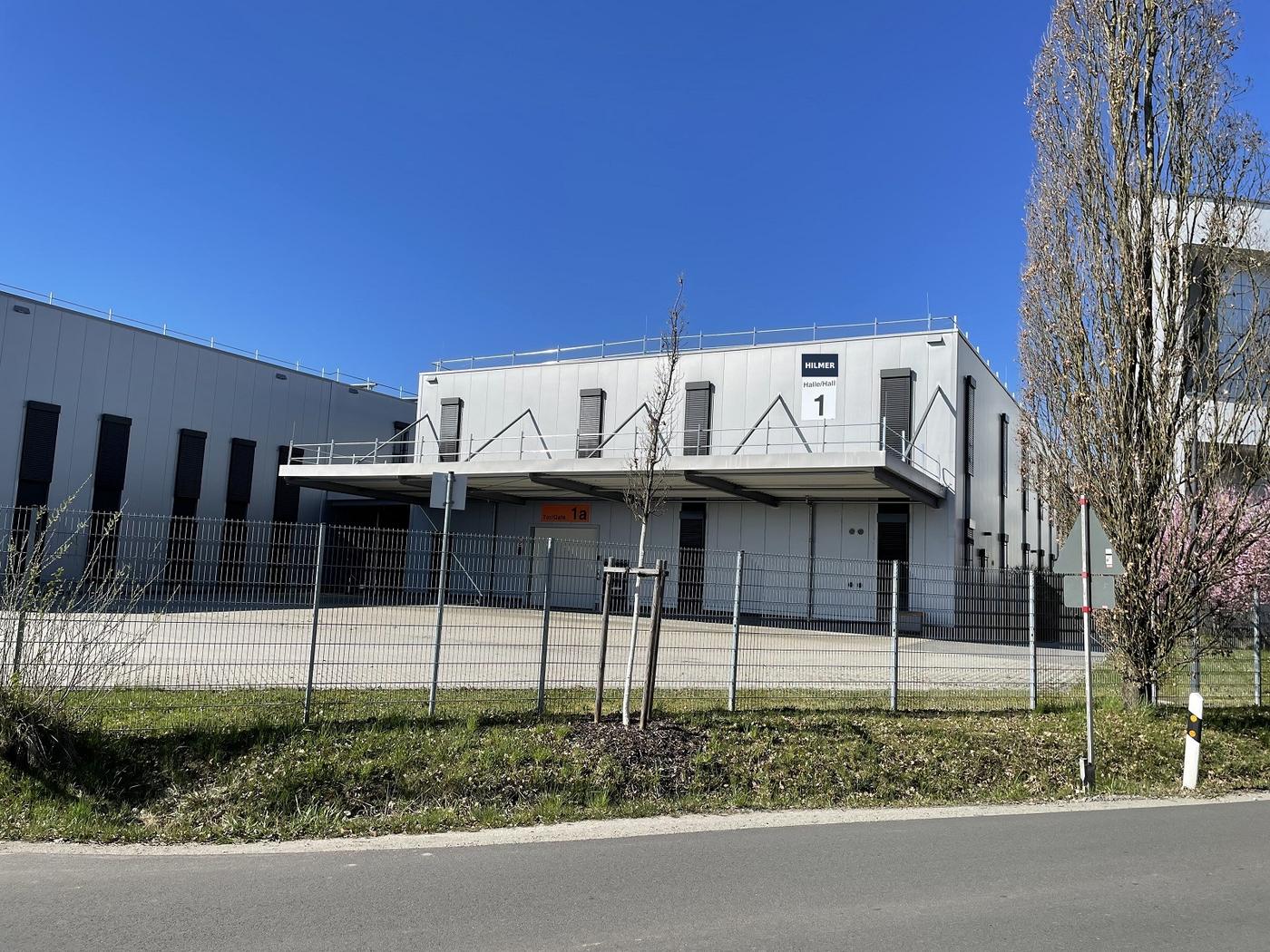 Halle mit zweigeschossigem Kopfbau, überdachtem Tor und befestigter Hoffläche